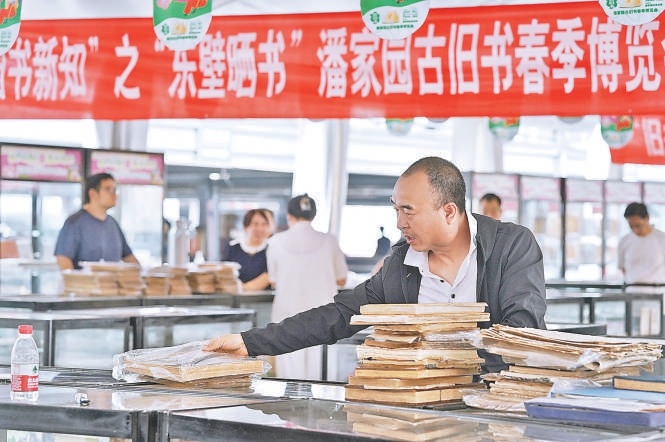 5月23日，书友在博览会现场淘宝。