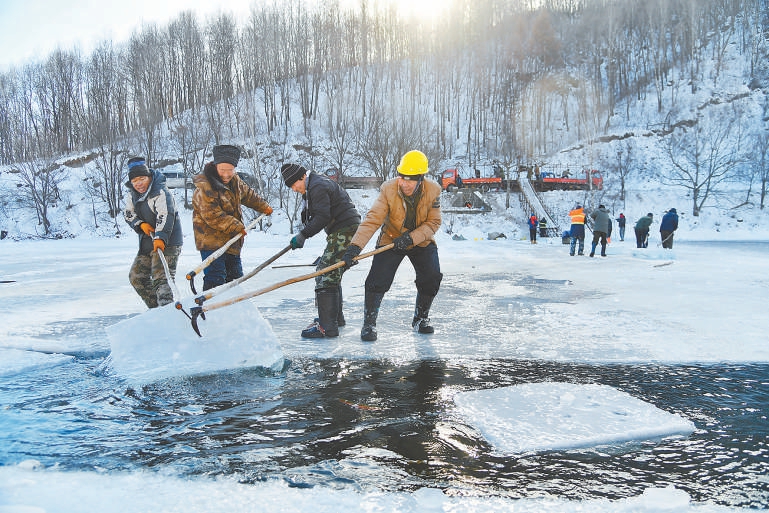 　　取冰师傅正在用冰钩将冰块从水下取出。